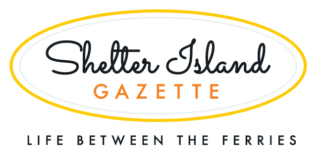 Shelter Island Gazette in fancy script inside oval with tagline Life Between the Ferries below in plain text.