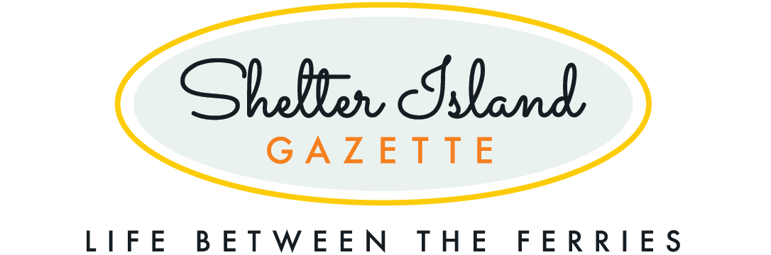 Shelter Island Gazette in fancy script inside oval with tagline Life Between the Ferries below in plain text.